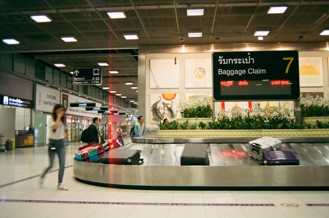 Checked suitcase moving through an airport baggage area